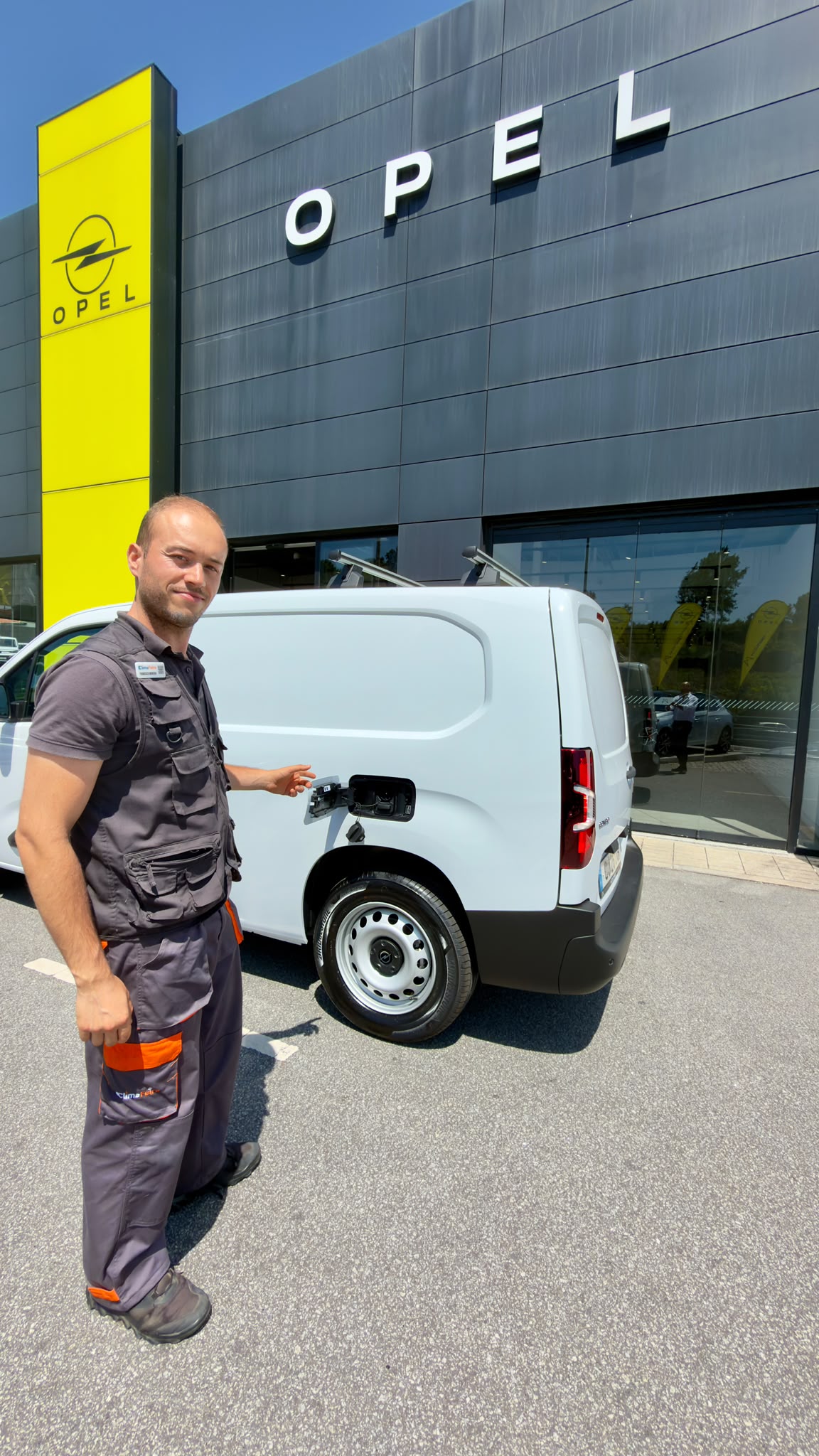 Técnico da Climafeira junto à nova viatura elétrica da empresa, a carregar